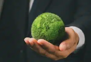 Imprenditore con piccolo mappamondo verde in mano