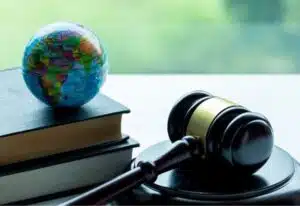 libri diritto ambientale con mappamondo e martello giudice