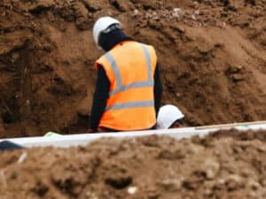 operaio durante lavori in un cantiere con terra e rocce da scavo