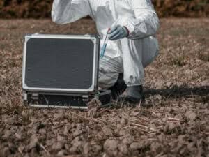 operaio con tuta bianca completa durante l'analisi del terreno operaio con tuta bianca completa durante l'analisi del terreno